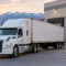 White semi-truck trailer parked at warehouse loading dock with forklift loading pallets in Salt Lake City
