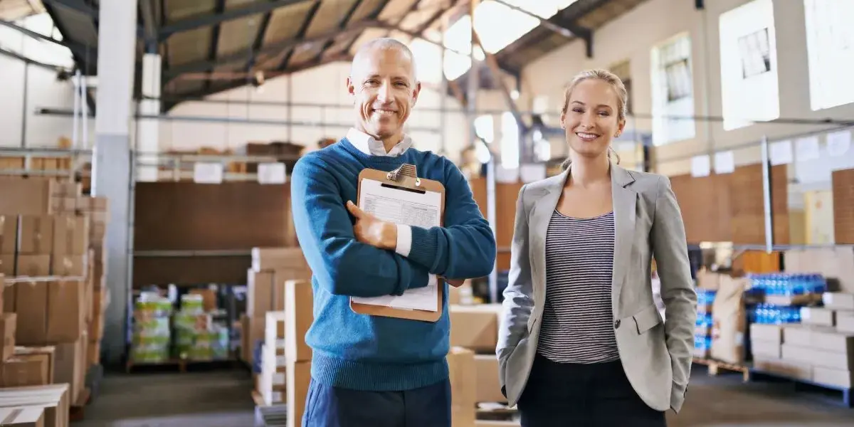 Logistics manager and colleague smiling in a Salt Lake City, Utah warehouse