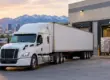 White semi-truck trailer parked at warehouse loading dock with forklift loading pallets in Salt Lake City