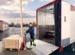 Freight truck with a lowered lift gate and palletized cargo at a delivery location